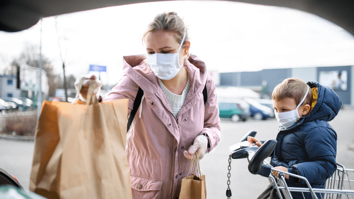 Everything we know (so far) about how states reopening will affect families mom and son loading groceries wearing masks