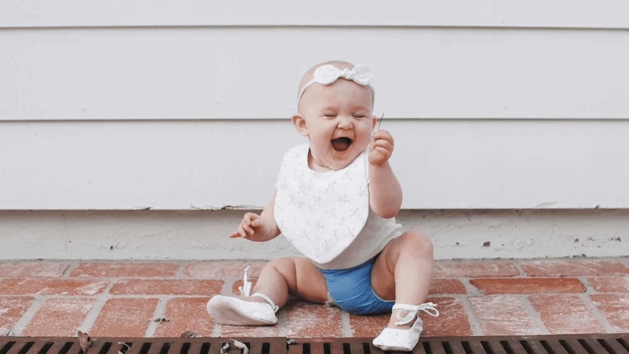 6 reasons why July babies are special, according to science baby laughing at a piece of grass- july babies