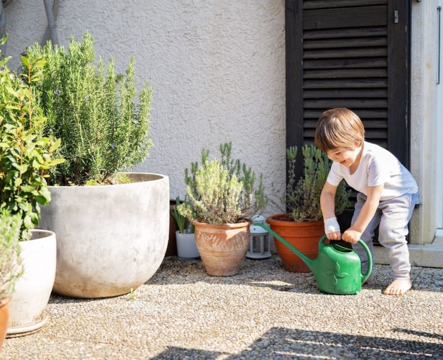 21 inspiring patio ideas to spruce up your backyard little boy on patio with watering can