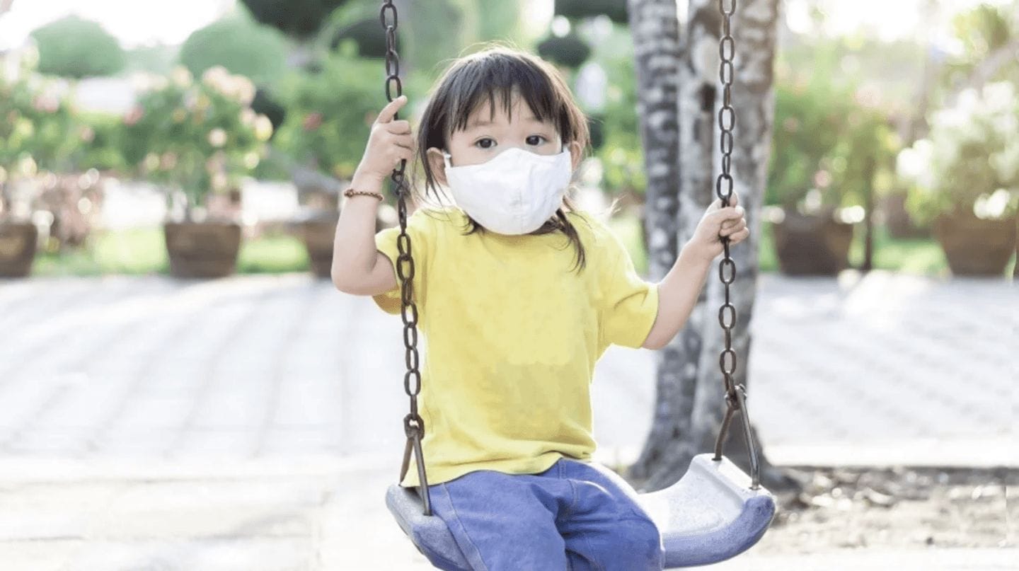 6 tips to safely get back to the playground during the pandemic child wearing mask on a swing