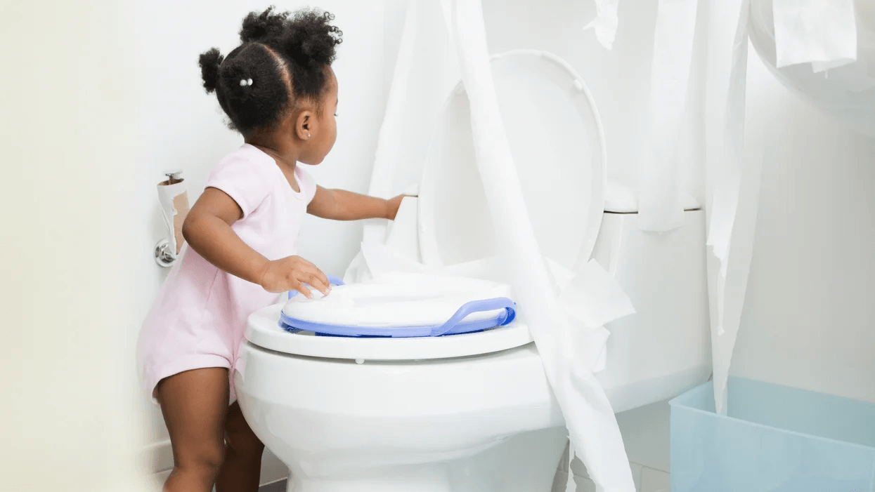 Why is my potty-trained child regressing? Here’s what to do, mama little girl playing with toilet paper