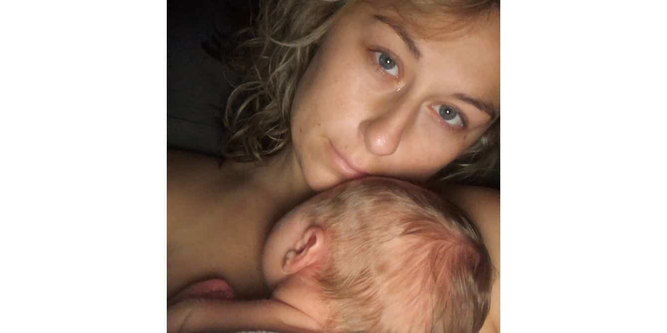 Kourtney on breastfeeding struggles triggering postpartum depression selfie of a mom with her son against her chest - essay on breastfeeding struggles triggering postpartum depression