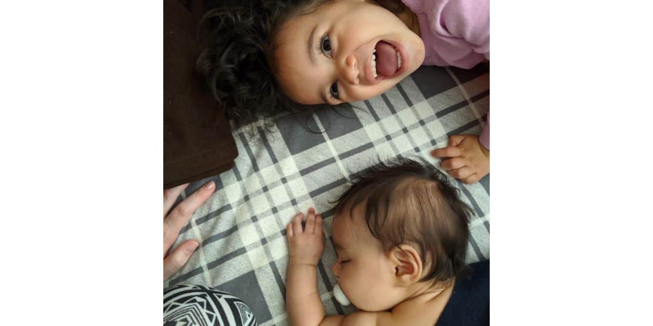 Grace on mothering and working with anxiety and depression during Covid-19 a toddler and a baby laying on a bed - essay on mothering and working with postpartum depression during covid-19