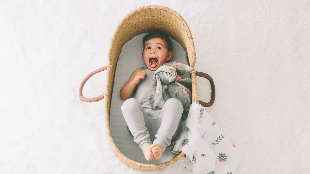 8 expert tips for managing the toddler sleep regression toddler laughing in a bassinet
