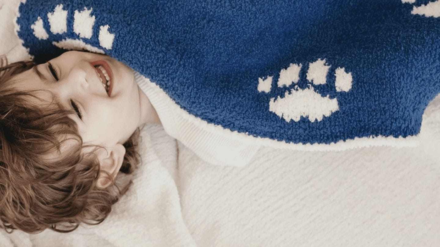 11 cozy products that will add extra hygge to your home child wrapped in Sunday Citizen blanket - home hygge decor