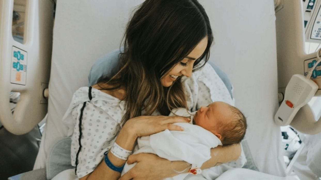 10 newborn photo ideas that you’ll cherish forever mom holding her new baby in the hospital, one of motherly's favorite newborn photo ideas