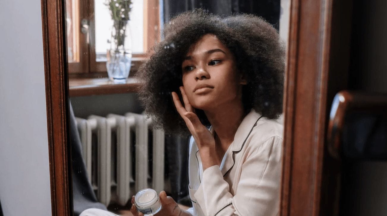 12 products that will bring the spa straight to your bathroom woman putting on face cream in the bathroom