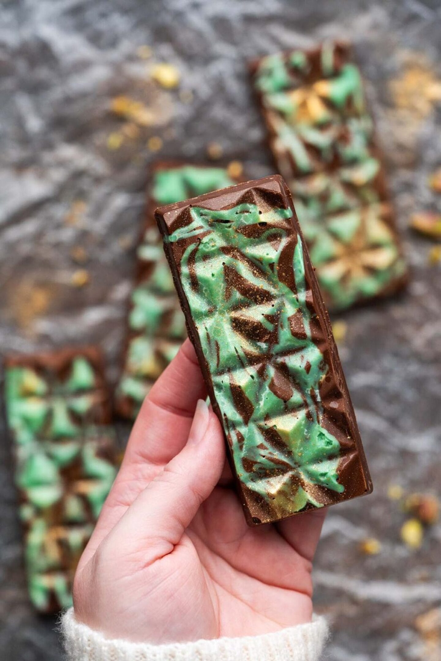 hand holding fancy pistachio chocolate bar - Motherly