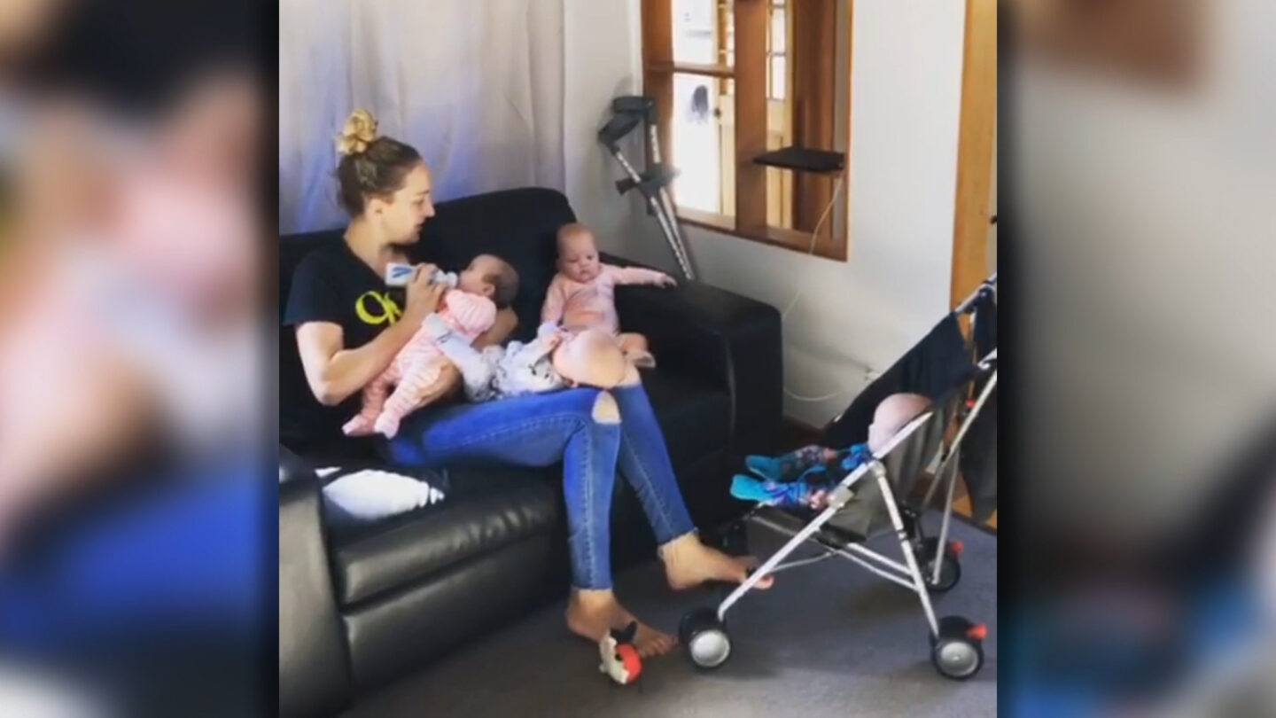 Viral video shows a day in the life of a mom with quadruplets mom of quadruplets holding two babies and pushing on in a stroller
