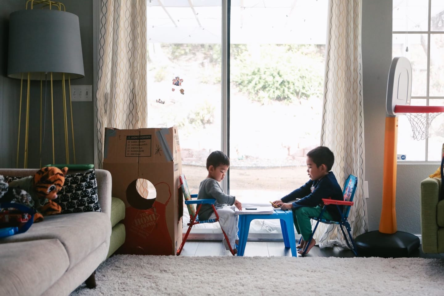 The best developmental toys for babies and kids, according to an early childhood development expert two kids sitting at a table playing with pen and paper, one of the best developmental toys for children