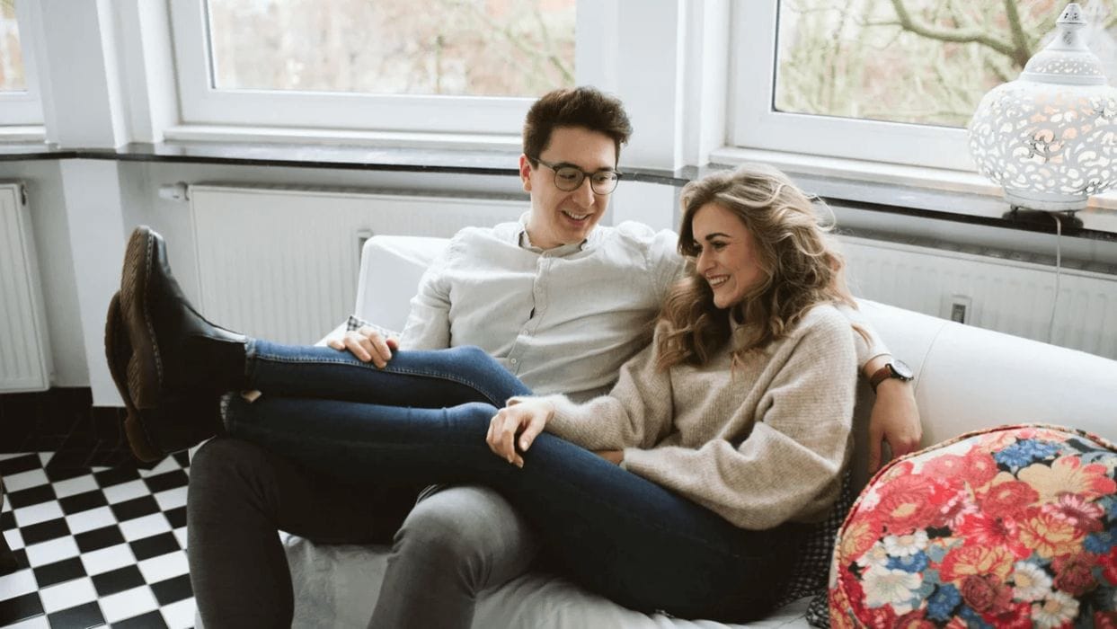 4 cozy at-home date night ideas (for after the kids go to bed) couple sitting on the couch snuggling