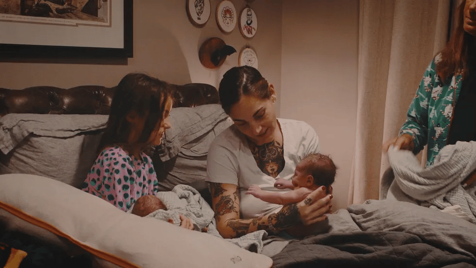 This is birth: A twin family home birth mom showing new baby to her older child
