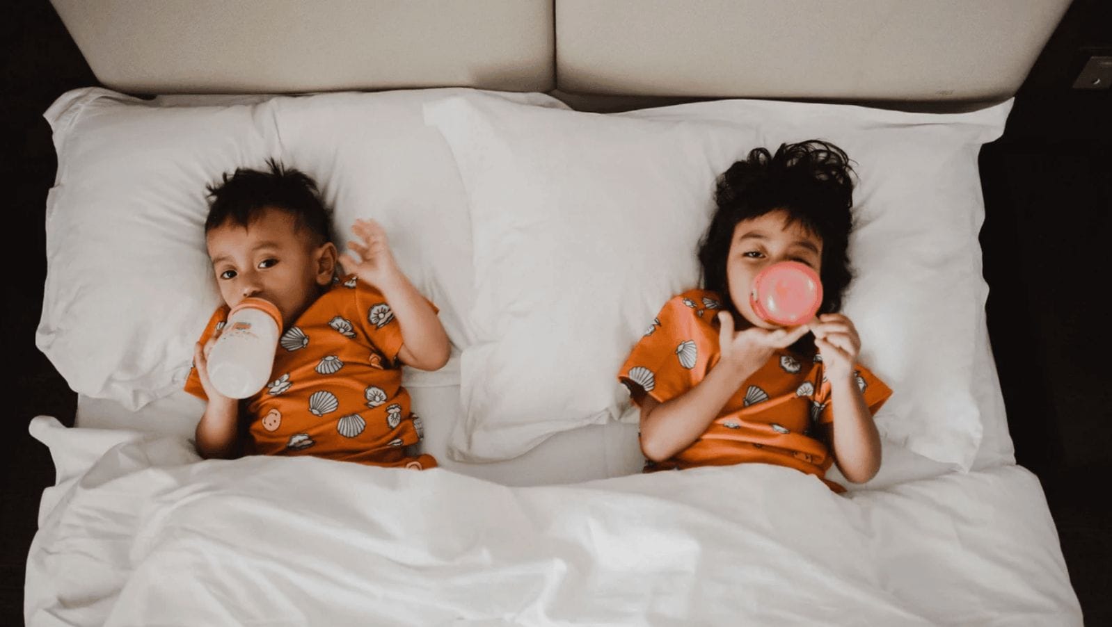 5 lies I believed about sleep before I became a mom two kids laying in bed- baby's sleep schedule