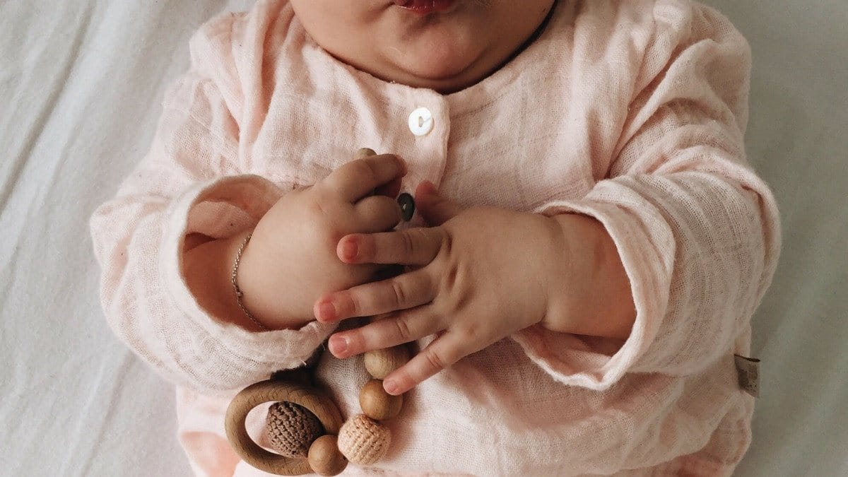 The best Montessori toys for newborns to 2-year-olds baby playing with wooden teething toy
