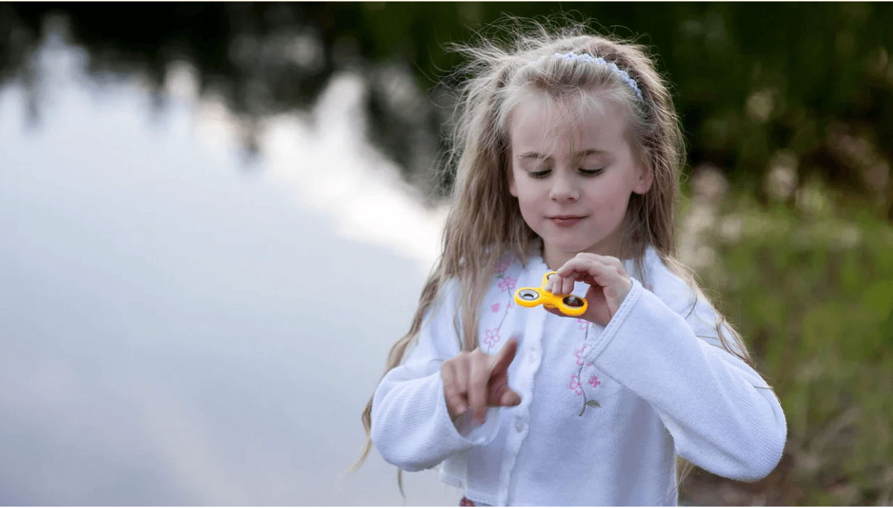 12 safe fidget toys that soothe anxiety and help kids focus little girl playing with a fidget toys