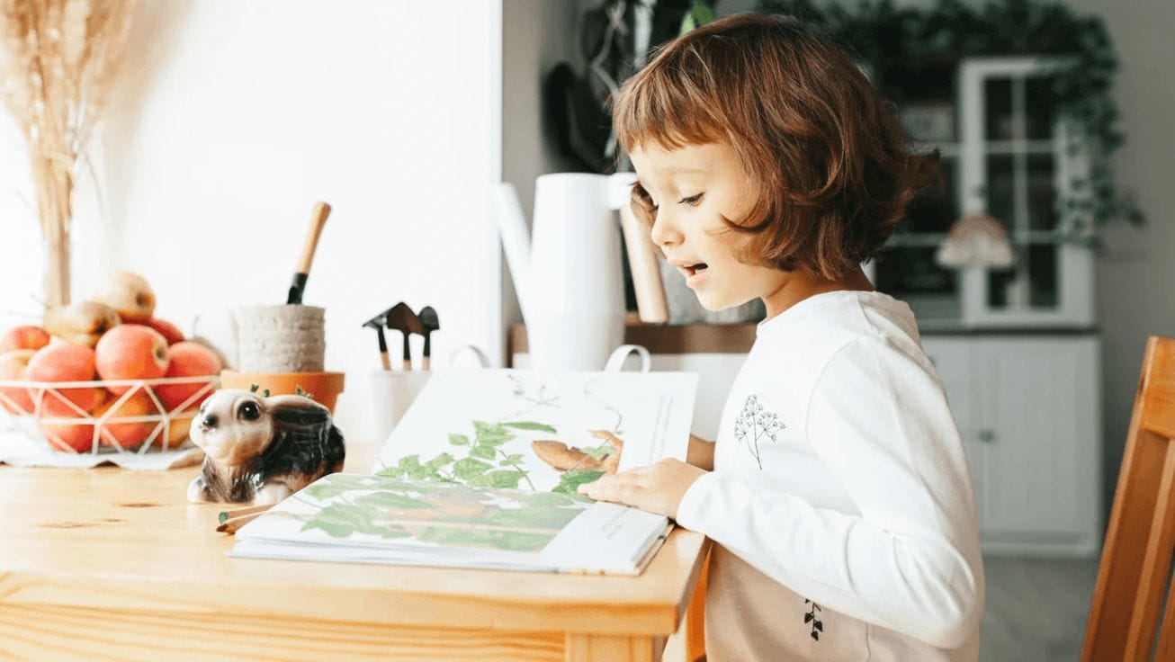 15 great children’s books about the environment to read for Earth Day little girl reading a book at the table
