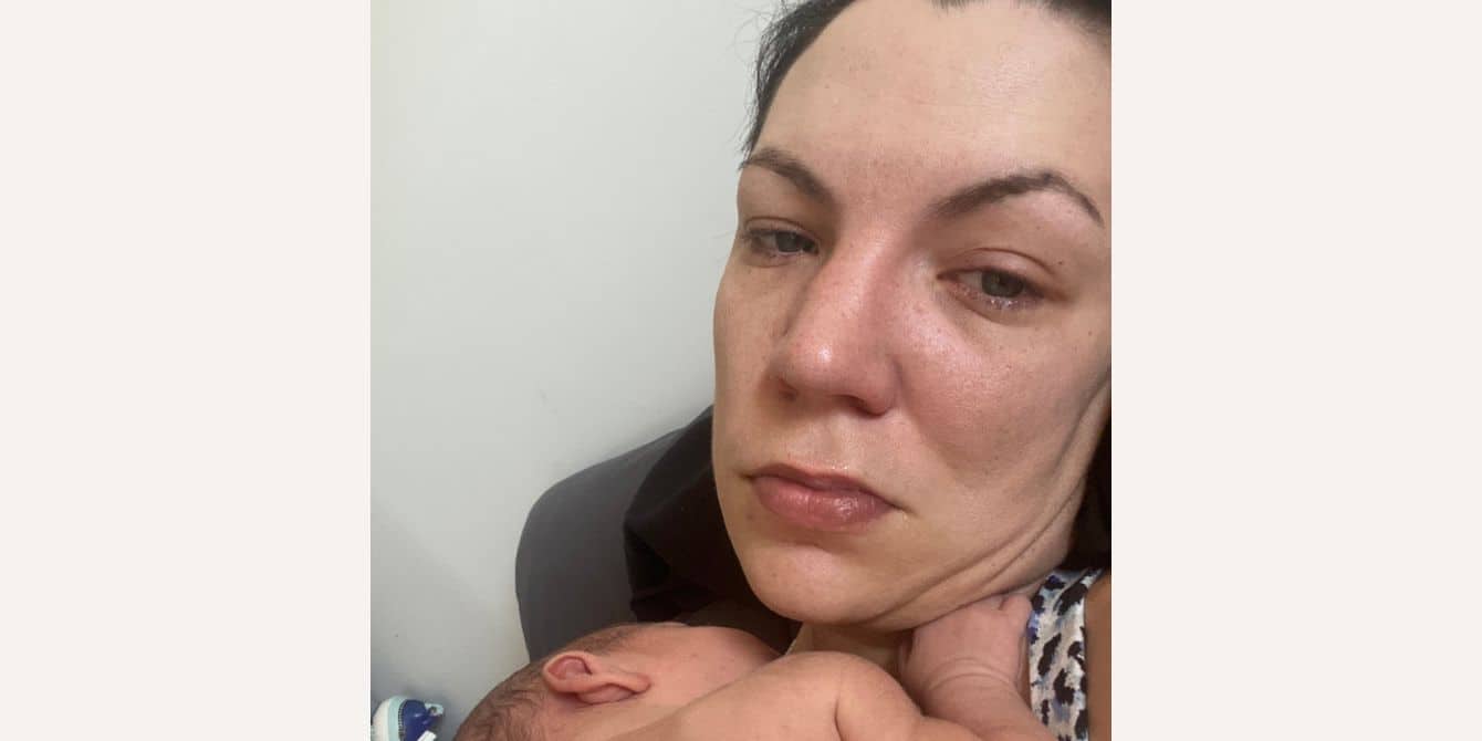 Suzanne on postpartum depression, PTSD and waiting to feel something for her son crying mom holding her sleeping baby - essay on PNDA and PTSD