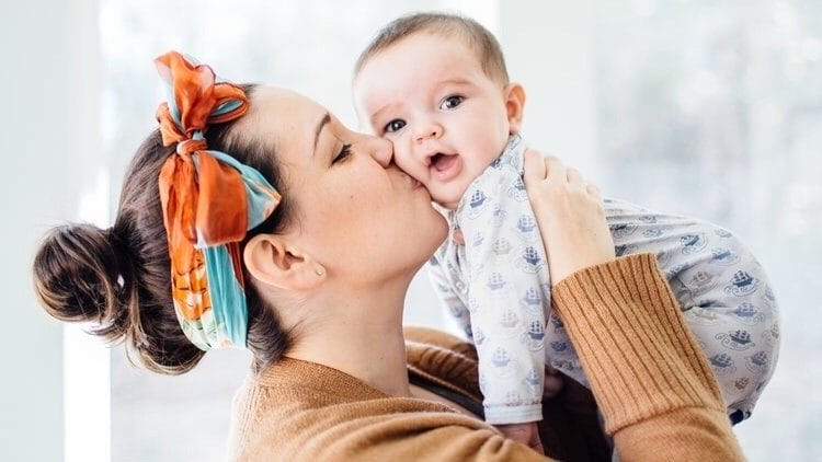 Mama, stop worrying about these 5 things when it comes to your child’s development mom kissing baby on the cheek