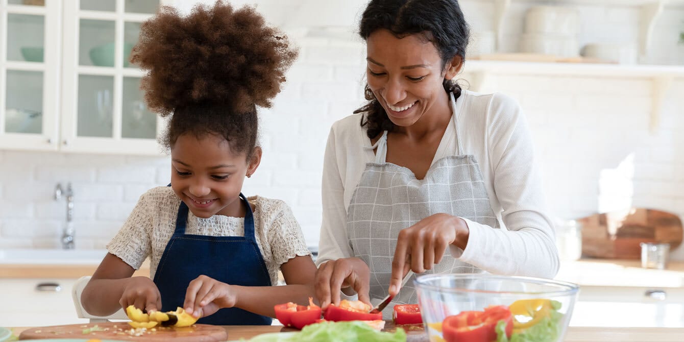 mom and daughter chopping vegetables in the kitchen - Motherly
