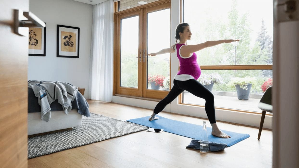How should I modify my workouts while pregnant? pregnant woman doing yoga
