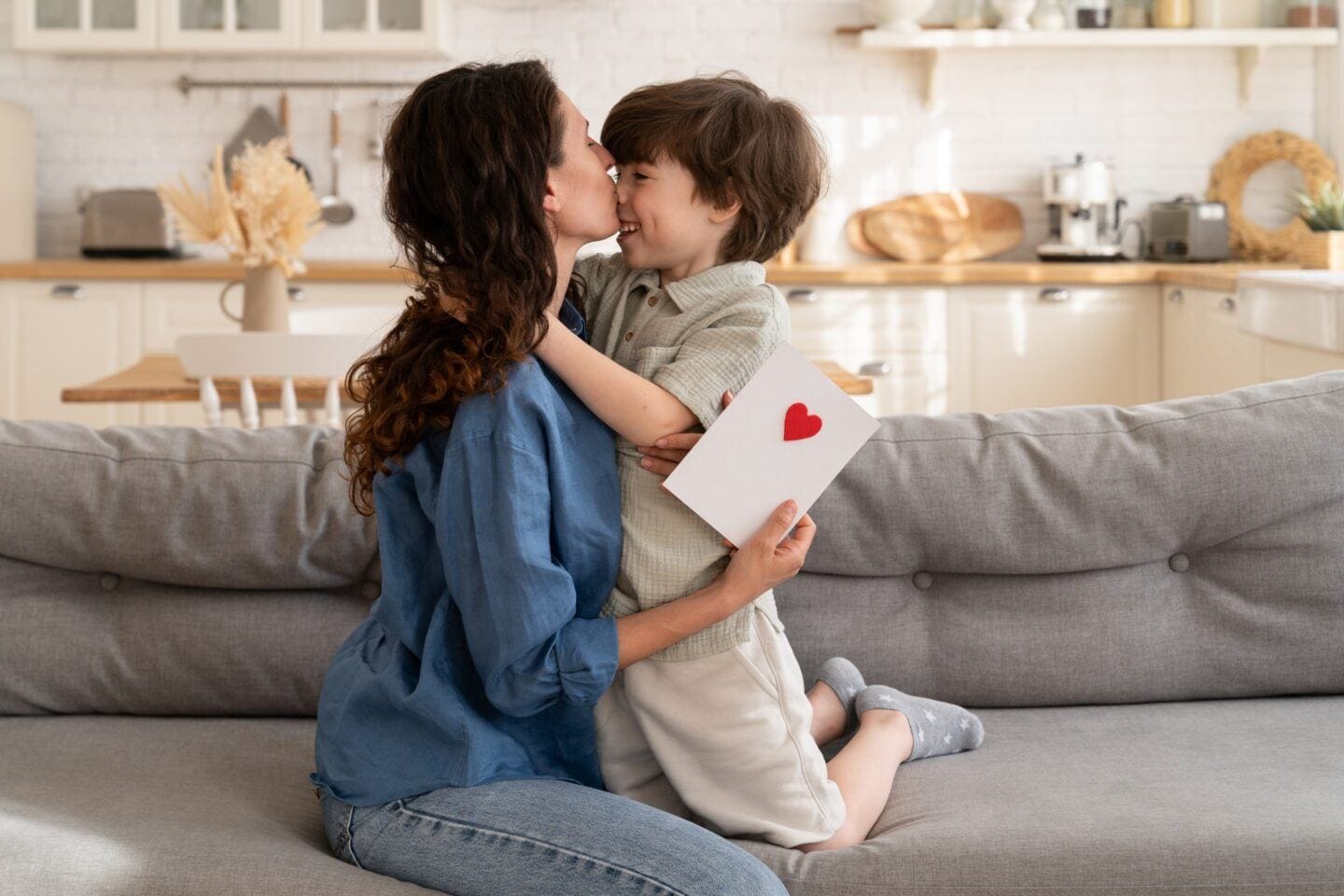 What sensitive boys need from their mamas mom kissing highly sensitive child on cheek holding a handmade card