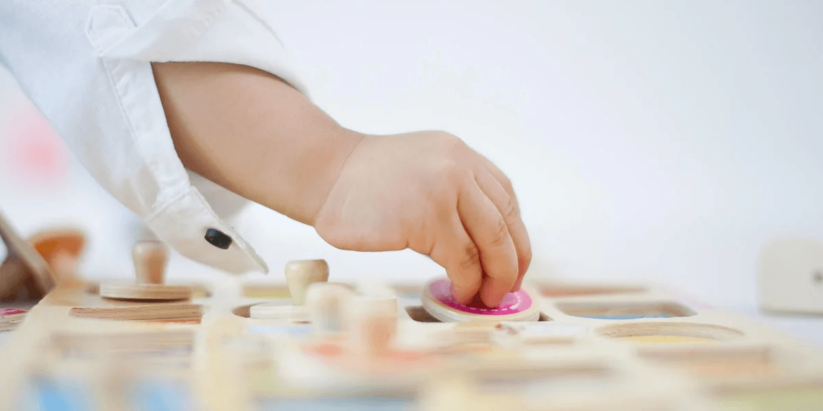 10 amazing Montessori-inspired activities for quiet time toddler hand playing with a wooden puzzle