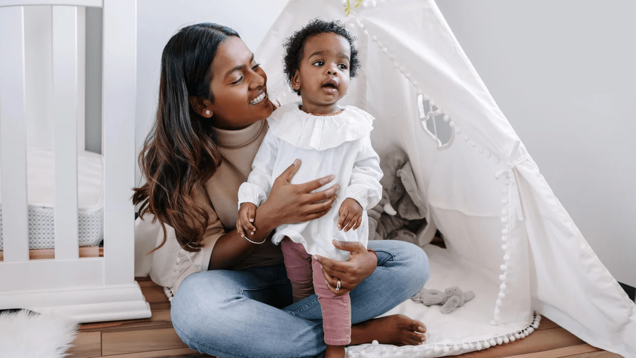 9 phrases Montessori teachers use to build resilient kids mom sitting with toddler in front of a tent
