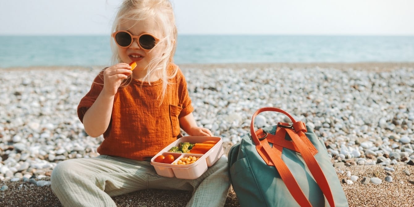 13 tried and tested lunch boxes for kids of all ages girl-sitting-outside-eating-lunch