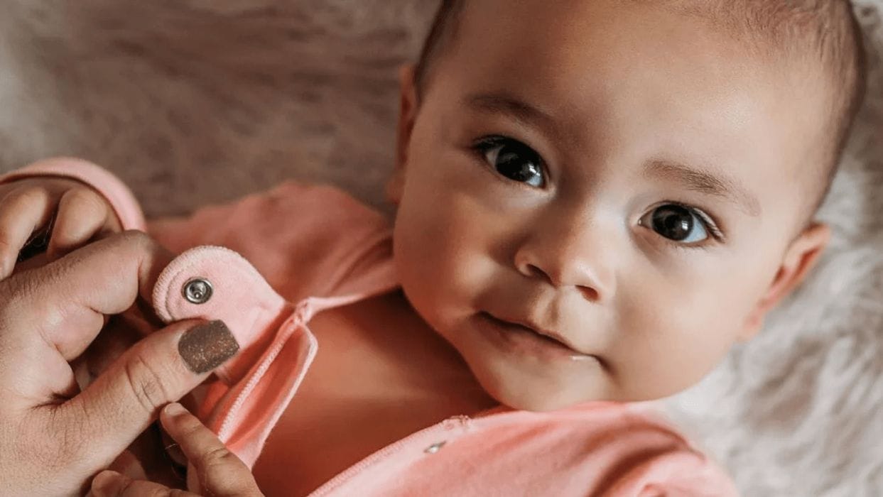 Looking for organic baby clothes? Here are the brands we adore 😍 baby looking at the camera in organic baby clothes