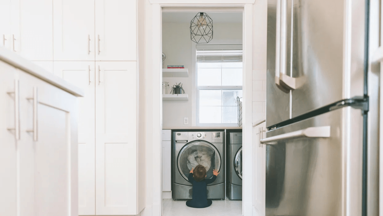 5 chic machine-washable rugs so you can worry about more important things kid sitting in front of a washing machine