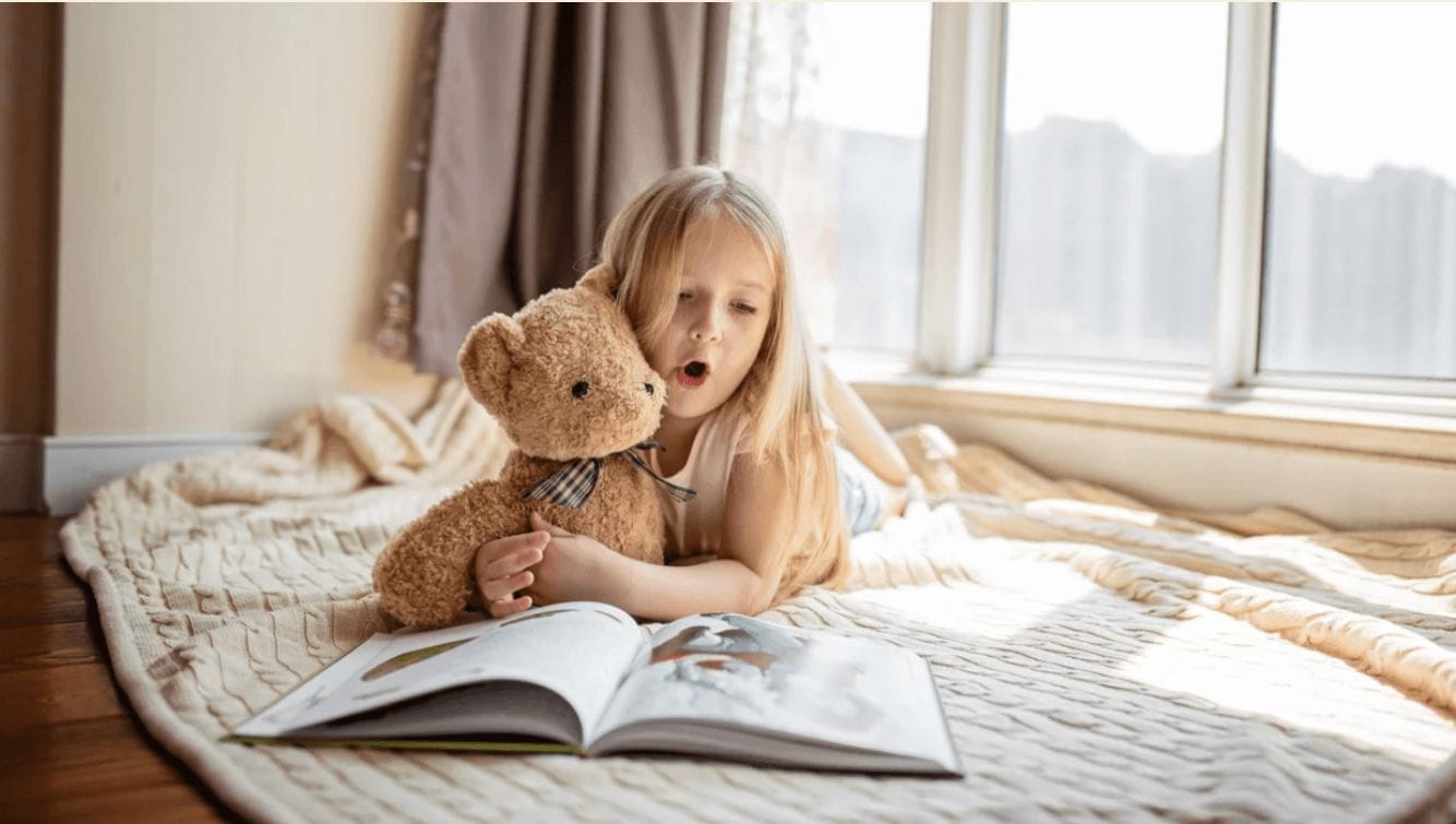 23 great toddler books they’ll adore little girl reading on a bed