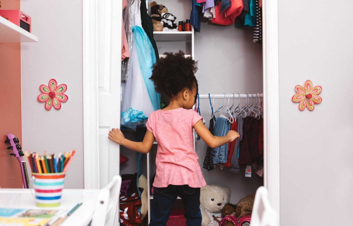 How to organize your kid’s closet at every age—from babies to teenagers little girl opening her closet