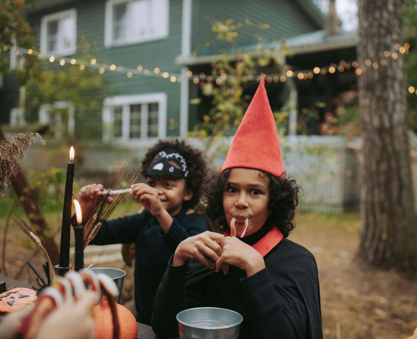 Outdoor Halloween decorations to make your house more haunted little kids eating halloween candy at a picnic table - halloween outdoor decorations