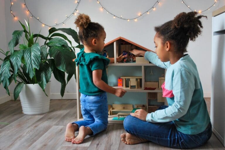 Less really is more: How to parent like a minimalist two girls playing with a dollhouse