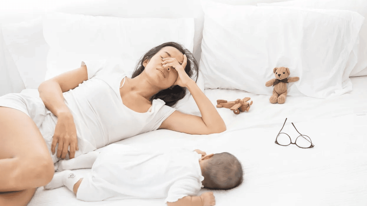 What no one tells you about your post-baby period woman-laying-with-baby-in-pain