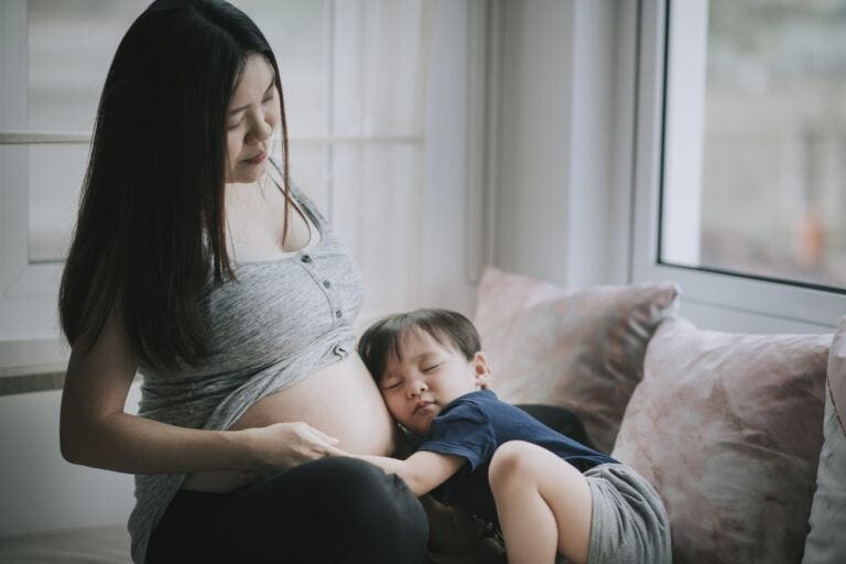To the mama preparing her heart for baby #2: You are ready ready for a second baby: toddler rests head on mother's pregnant belly