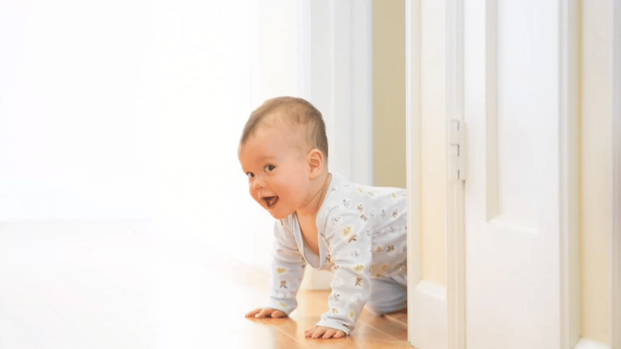 8-month-old baby milestones baby peeking around the corner crawling, one of the 8-month milestones for baby