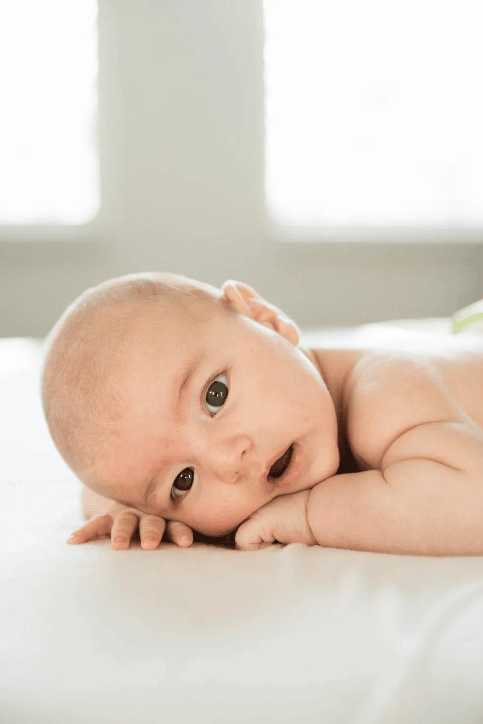2-month-old baby milestones cute baby laying on its stomach and making sustained eye contact, one of the 2-month milestones