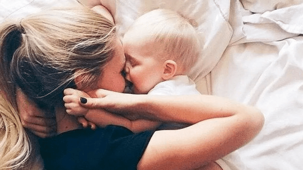 10 true things about the first year of motherhood mom laying with baby on a bed