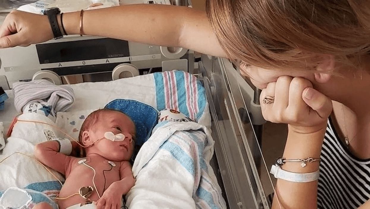 12 emotional photos of the moment when you first felt like a mother mom looking over baby in a hospital bed in a motherhood photo