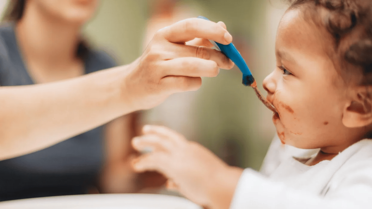 8-month-old baby feeding schedule & expert advice mom feeding baby with a spoon - 8-month-old baby feeding schedule