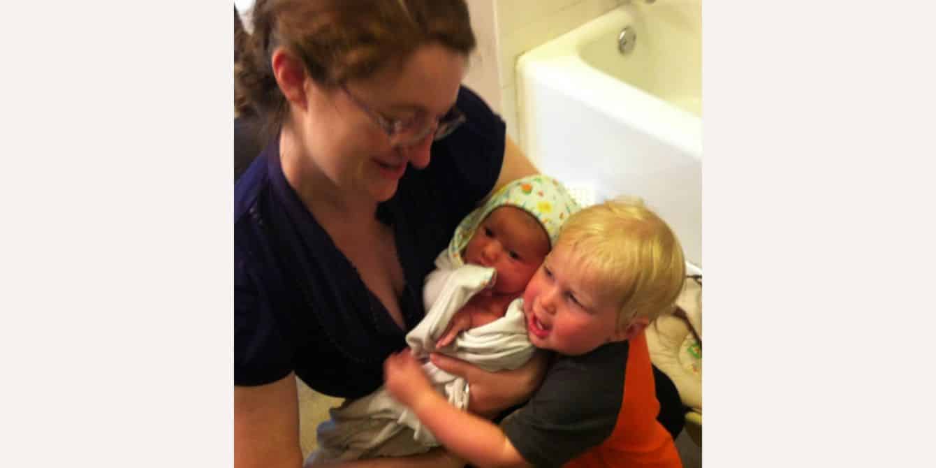 Trisha on feeling alone and isolated during postpartum depression mom holding two babies - essay on feeling alone and isolated with postpartum depression