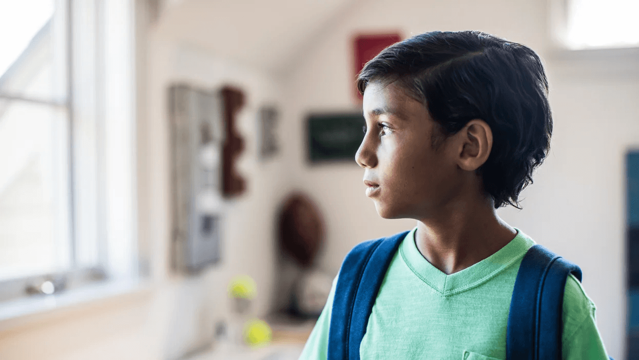 10 Montessori phrases for kids who are struggling with back to school kid-looking-out-window-at-school