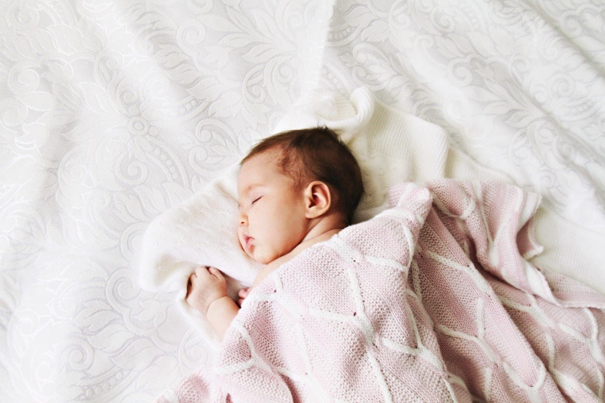 Thinking about sleep training? Rest easy, mama. baby sleeping on a blanket