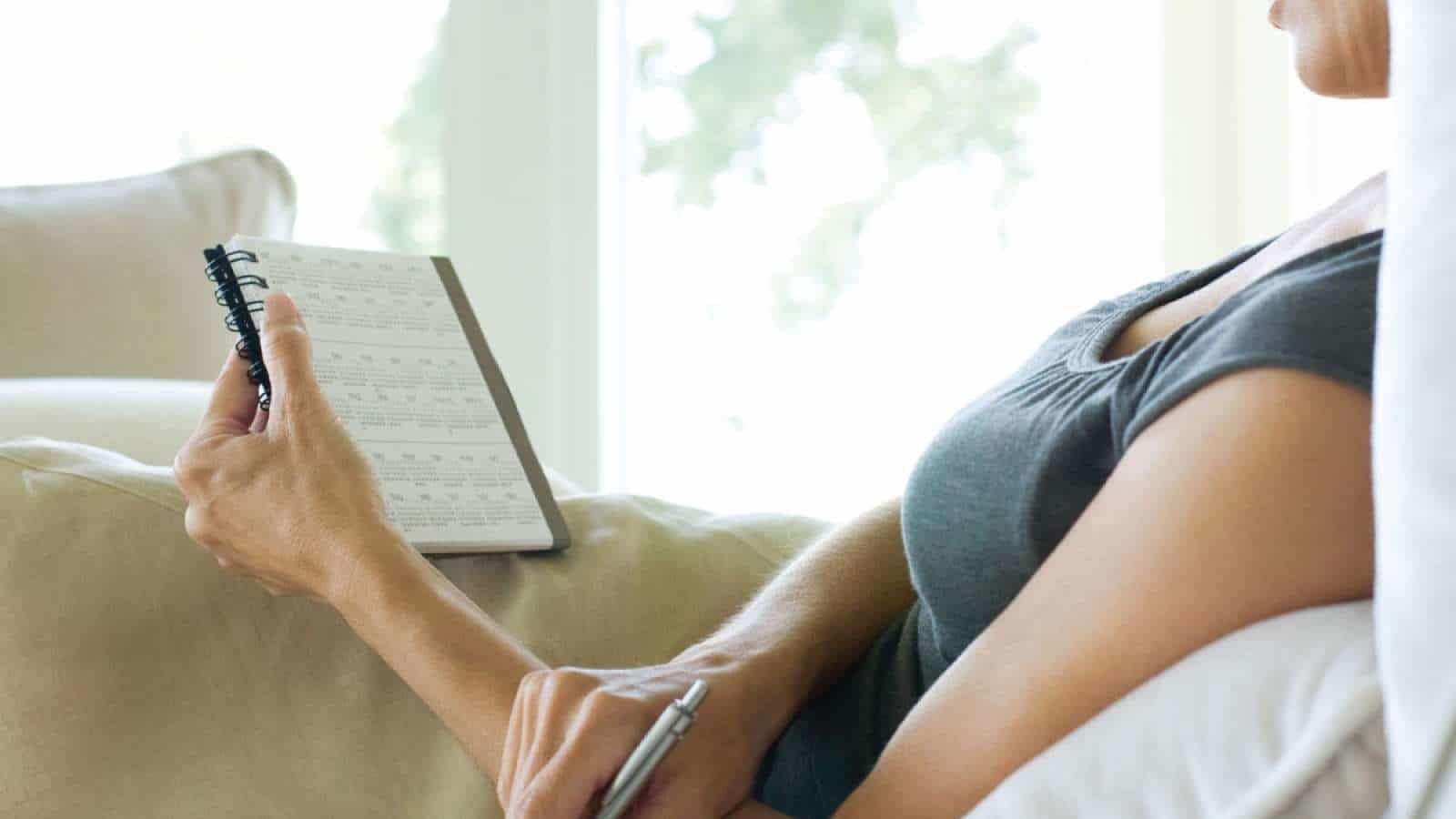 The grief of due dates—remembering my miscarried baby woman reading on the couch