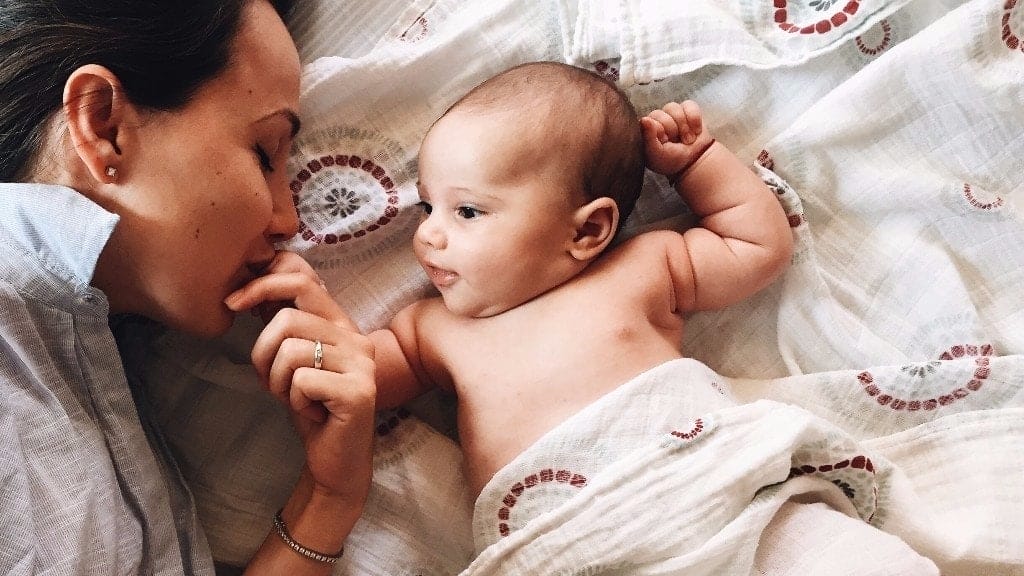 Being a stay-at-home parent is harder (and better) than people think dad laying with newborn baby