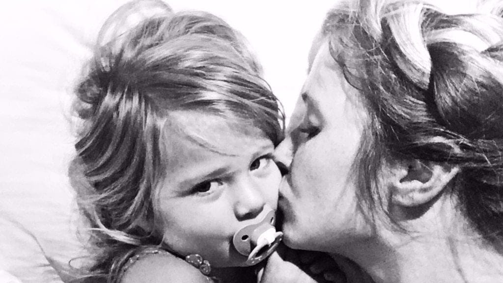 What do stay-at-home moms do all day? mom kissing daughter on the cheek