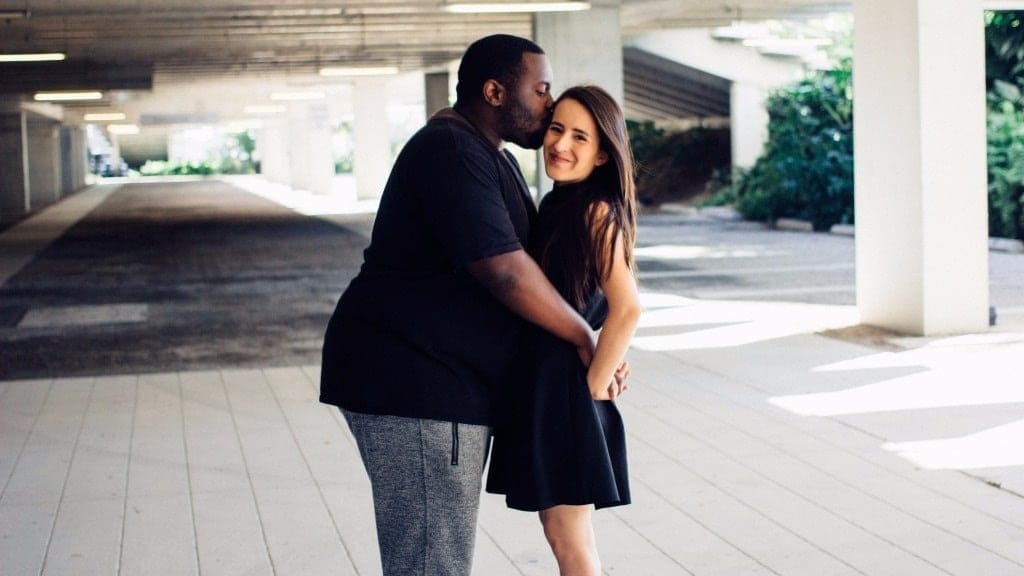 What partners can do: 5 strategies to support your partner when trying to get pregnant man kissing woman in a parking garage