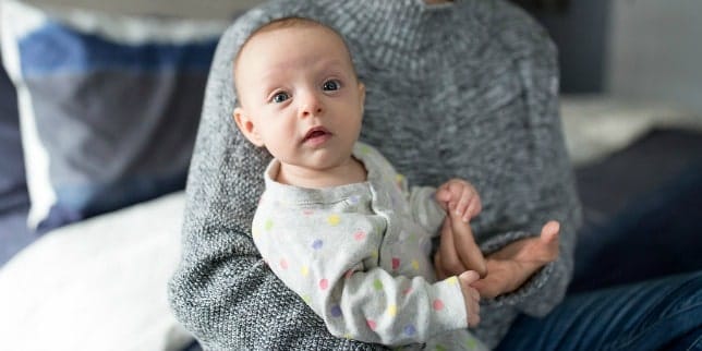 How to Get your Baby to Sleep When You’re Traveling baby sitting in parents lap
