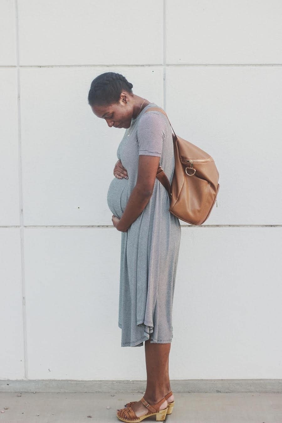 What is a breech baby? (and how to turn them, mama) pregnant mother cradling her belly, worried that her baby is breech
